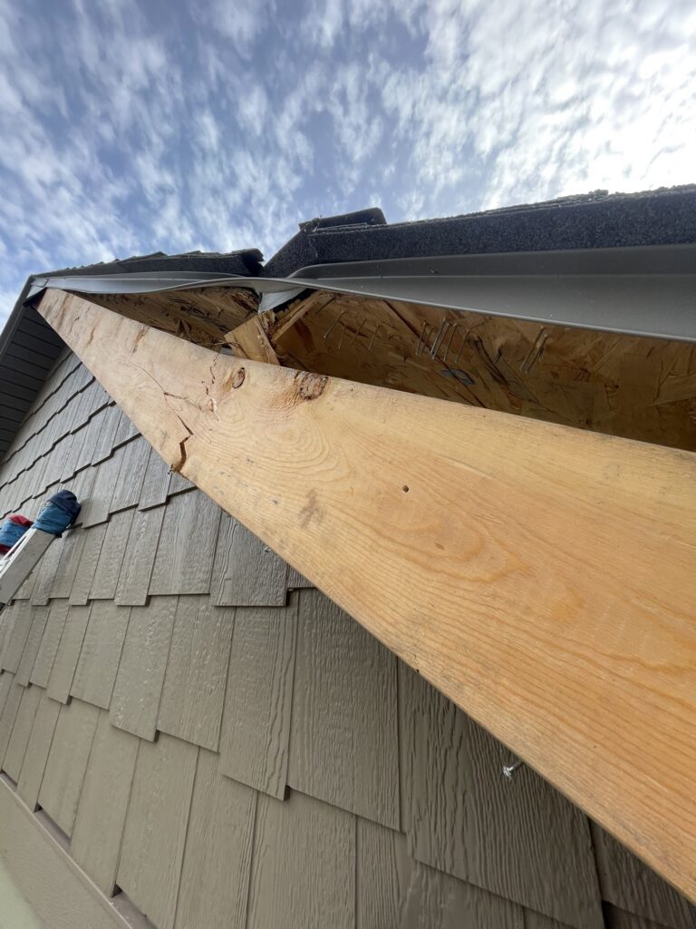 storm-damaged-roof-river-falls-wi Damaged roof shingles and roof edge before repairs in River Falls WI